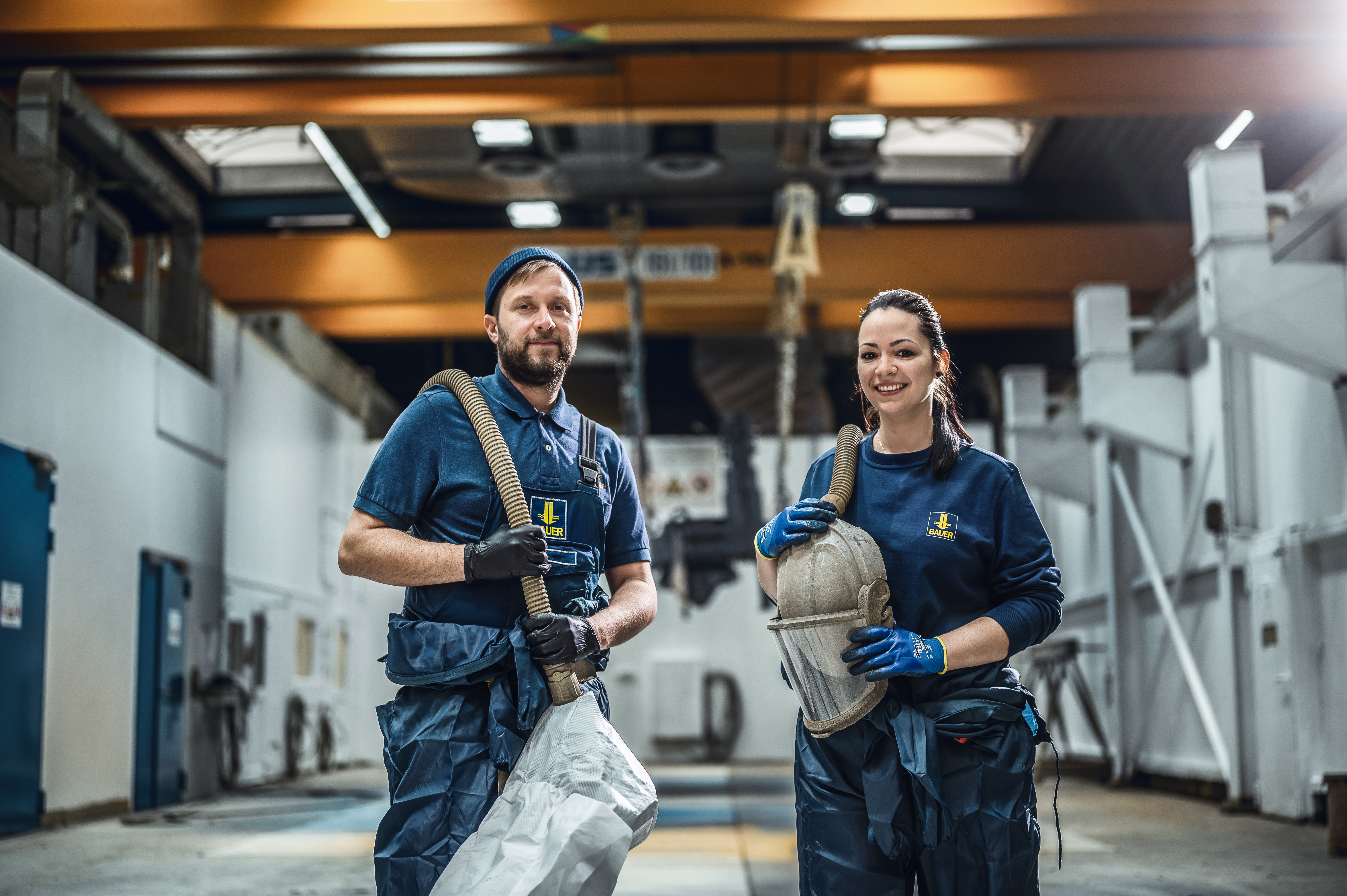 Teamkollegen in einer Produktionshalle bei BAUER im Werk Aresing